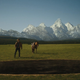 Royal Abbott (Josh Brolin) and his horse stand at the edge of a giant hole with a mountain range in the background.
